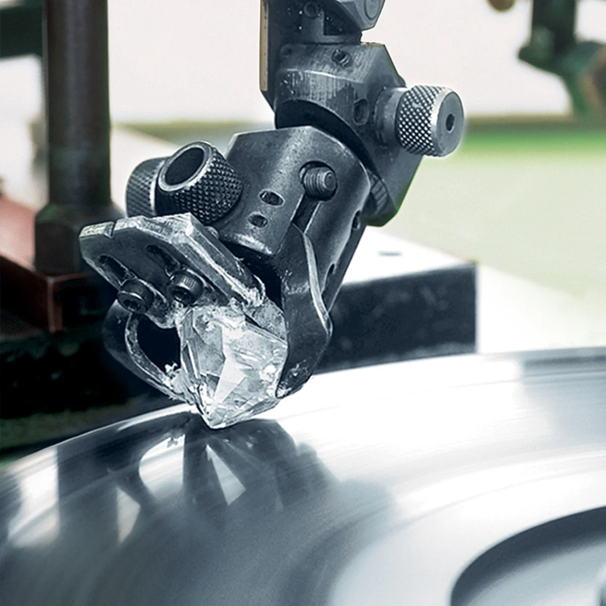 Skilled craftsman polishing a diamond to enhance brilliance and symmetry as explained in the diamond guide